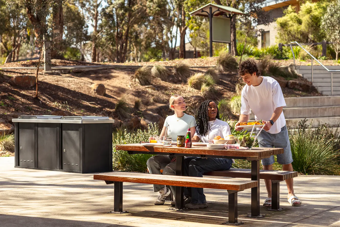 Amis autour d'un barbecue public dans un parc